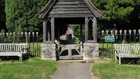 a quick aerial push-in shot following the path to the gate of st john the evangelist church in ickham, with the graveyard visible behind the fence