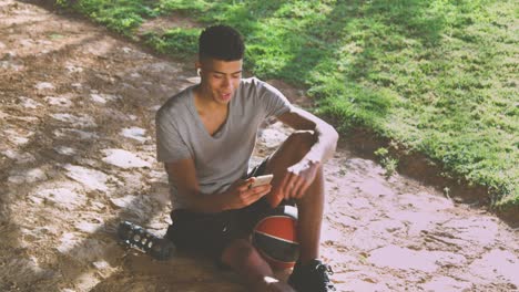 Black-sportsman-reading-messages-during-break