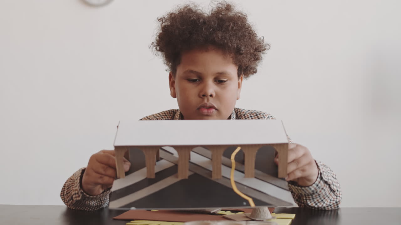 Bambino che tiene una miniatura di cartone
