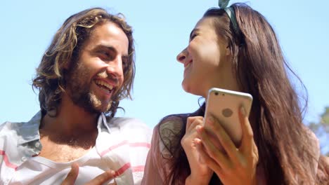 Couple-laughing-and-watching-smartphone-