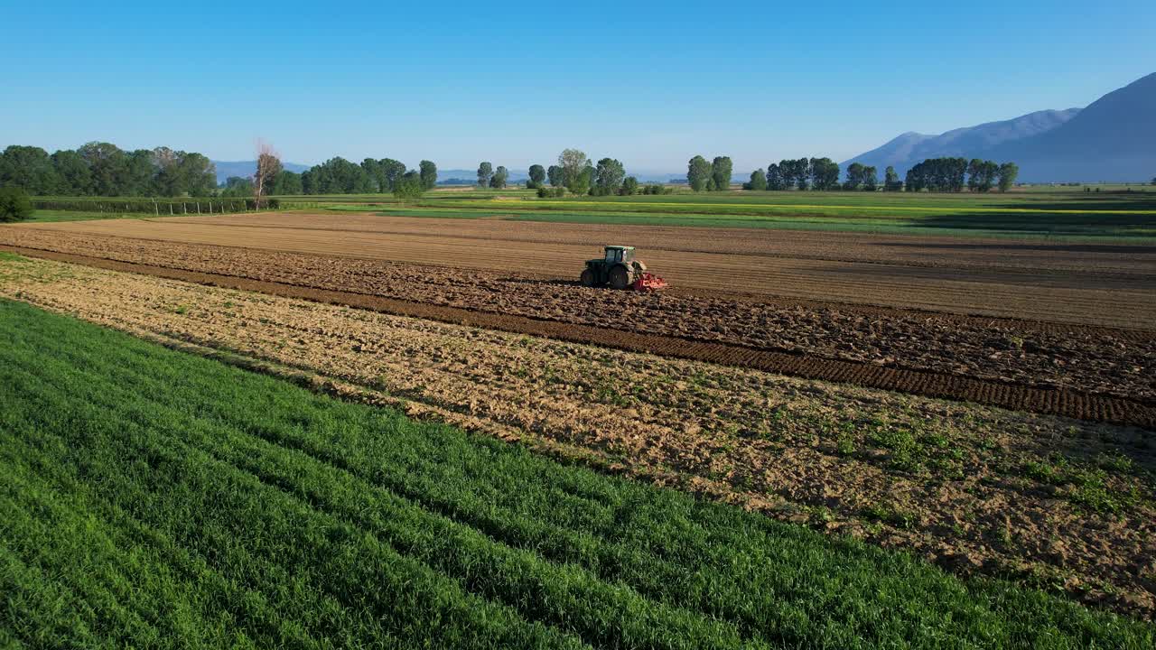 tractor trabajando los campos en hermosas parcelas agrícolas, cultivando la tierra para la agricultura en una mañana soleada