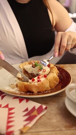 woman eating a sweet pastry at a restaurant