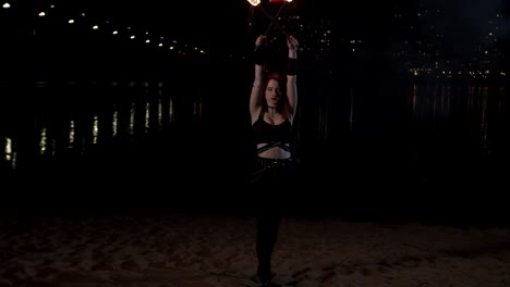 pretty firegirl juggling lit torches sitting down