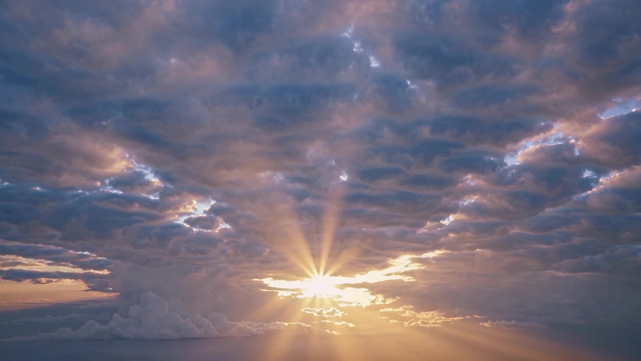 Golden Sun Rays Breaking Through Dramatic Clouds at Sunset