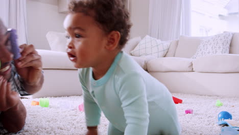 young black father lying on floor playing with his young son