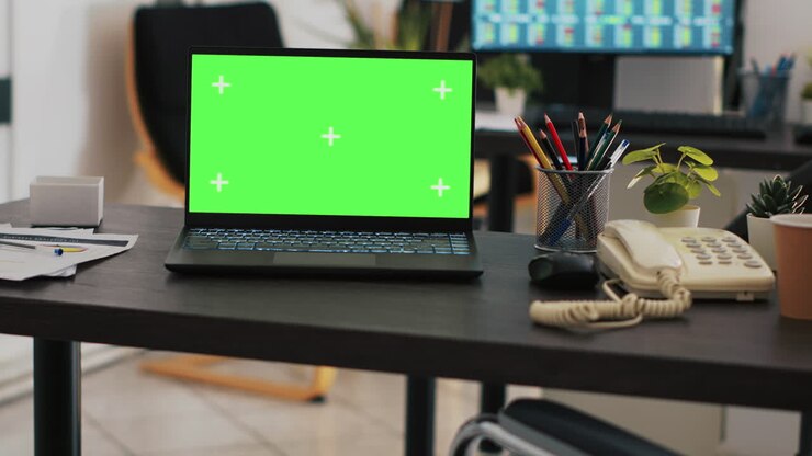 Nærbillede af en mockup-bærbar og en handelsplatform vist på en pc-skærm.