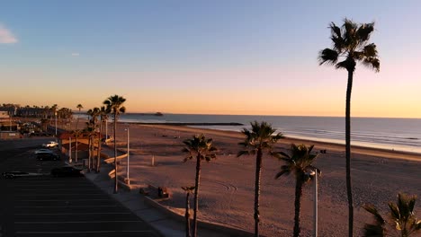 Wunderschöner-Sonnenuntergang-Von-San-Diego-Am-Strand,-Während-Sie-Sich-Entlang-Der-Palmen-Mit-Blick-Auf-Das-Wasser-Bewegen