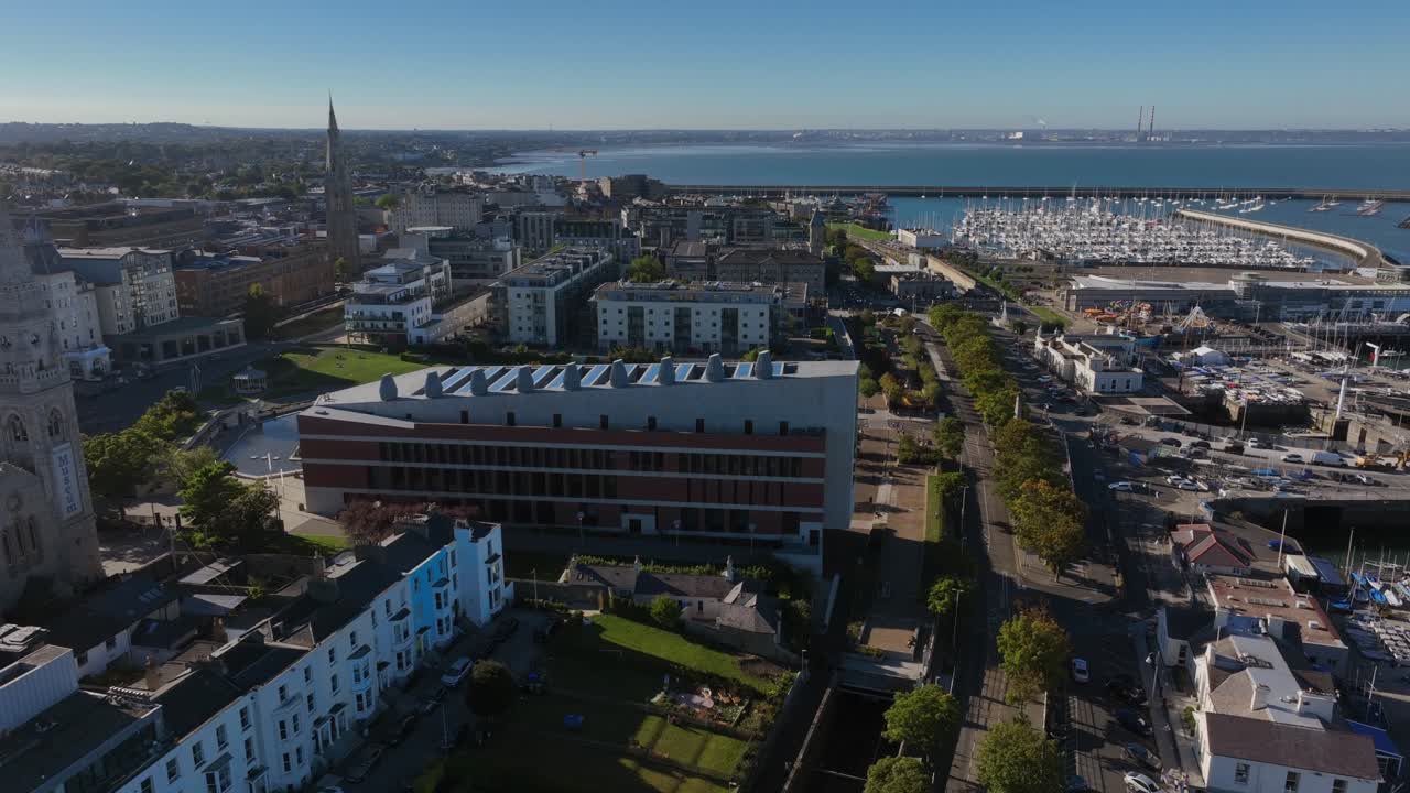 LexIcon, Dún Laoghaire, County Dublin, Ireland, September 2024. Drone high angle clockwise orbit around the iconic modern building with views of Yacht clubs and historic Harbour in the background.