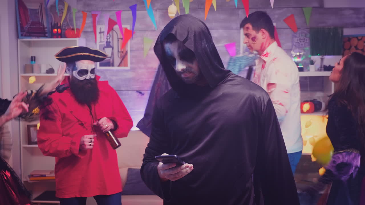 un joven aburrido vestido como la muerte.