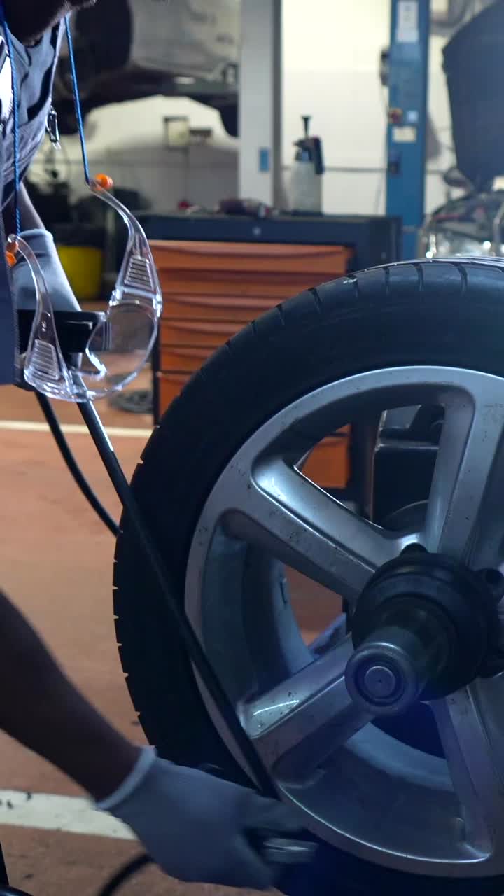 Car Mechanic Repairing Tire in Auto Repair Shop