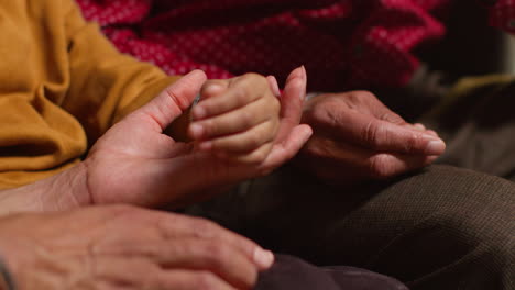 Close-Up-Of-Multi-Generation-Male-Sikh-Family-Wearing-And-Discussing-Traditional-Silver-Bangles-Or-Bracelets-Sitting-On-Sofa-At-Home-2