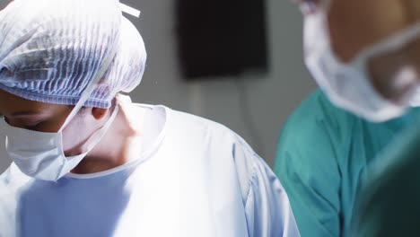 video of biracial female surgeon talking with colleagues during operation in theatre, copy space