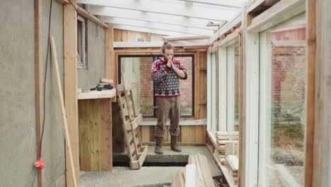 timelapse - hombre barriendo dentro del invernadero de nueva construcción con ventana de vidrio