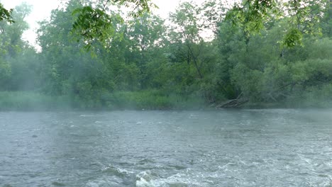 Beruhigendes-Fließendes-Wasser-Mit-Aufsteigendem-Dampf-Und-Grünem-Laub,-Statische-Aufnahme