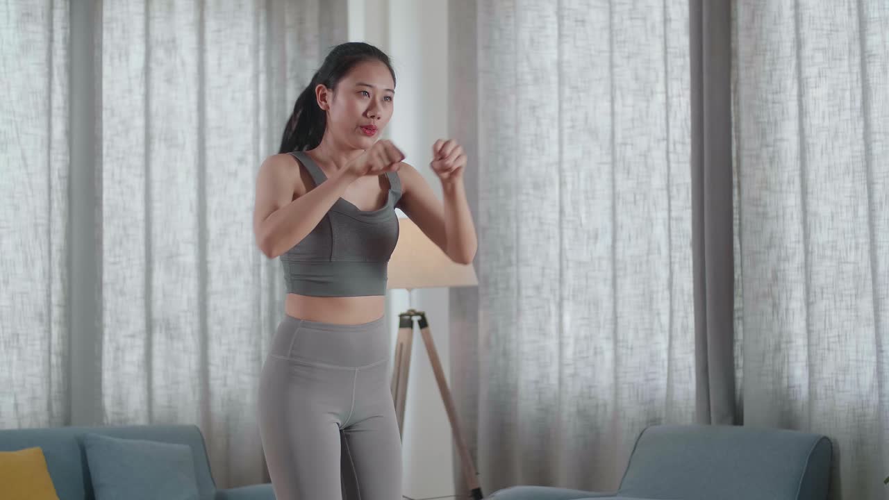 joven atleta asiática en ropa deportiva haciendo ejercicios de fortalecimiento del núcleo cardíaco en la alfombra en casa