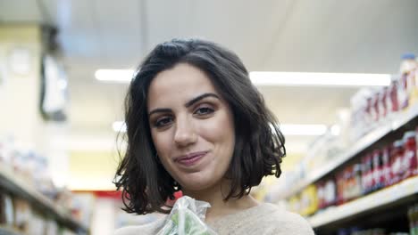 mujer feliz con bolsa de papel en el supermercado