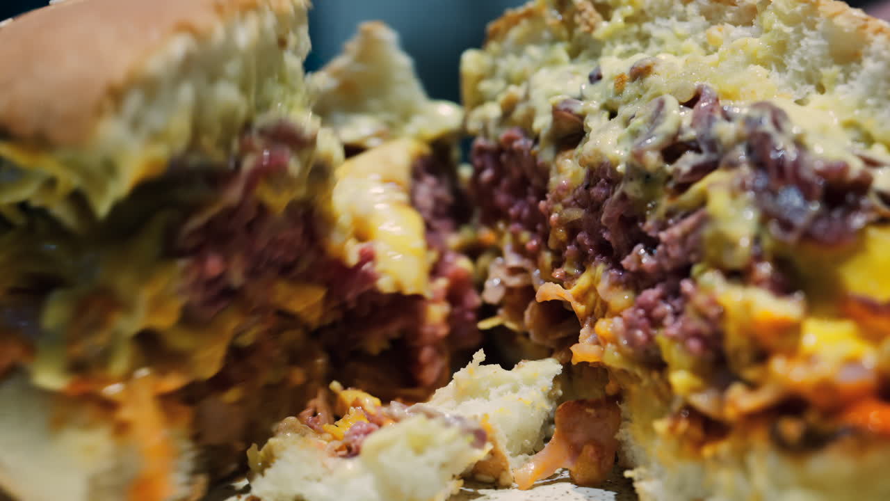 Close up of a woman cutting a burger on a plate at a restaurant