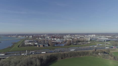 Drone-shot-of-city-and-highway-between-grass-fields