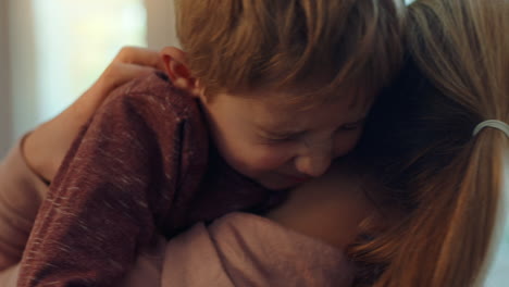 niño feliz abrazando a su madre disfrutando de la madre amorosa abrazando a su hijo en casa 4k imágenes