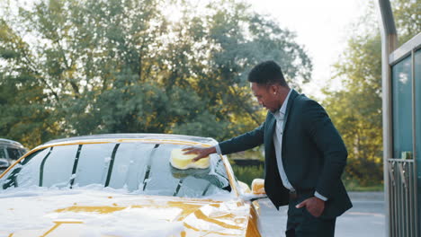 man washing a yellow car