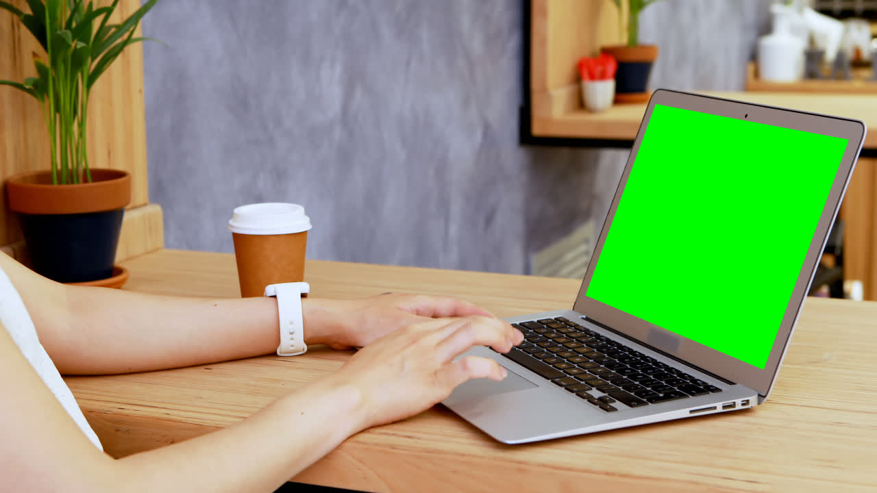 Female executive checking time on smartwatch while working at desk 4k