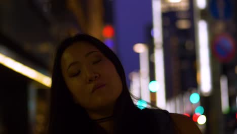 slow motion, low angle shot from the front, of a young female tourist looking at the streets of tokyo at dusk