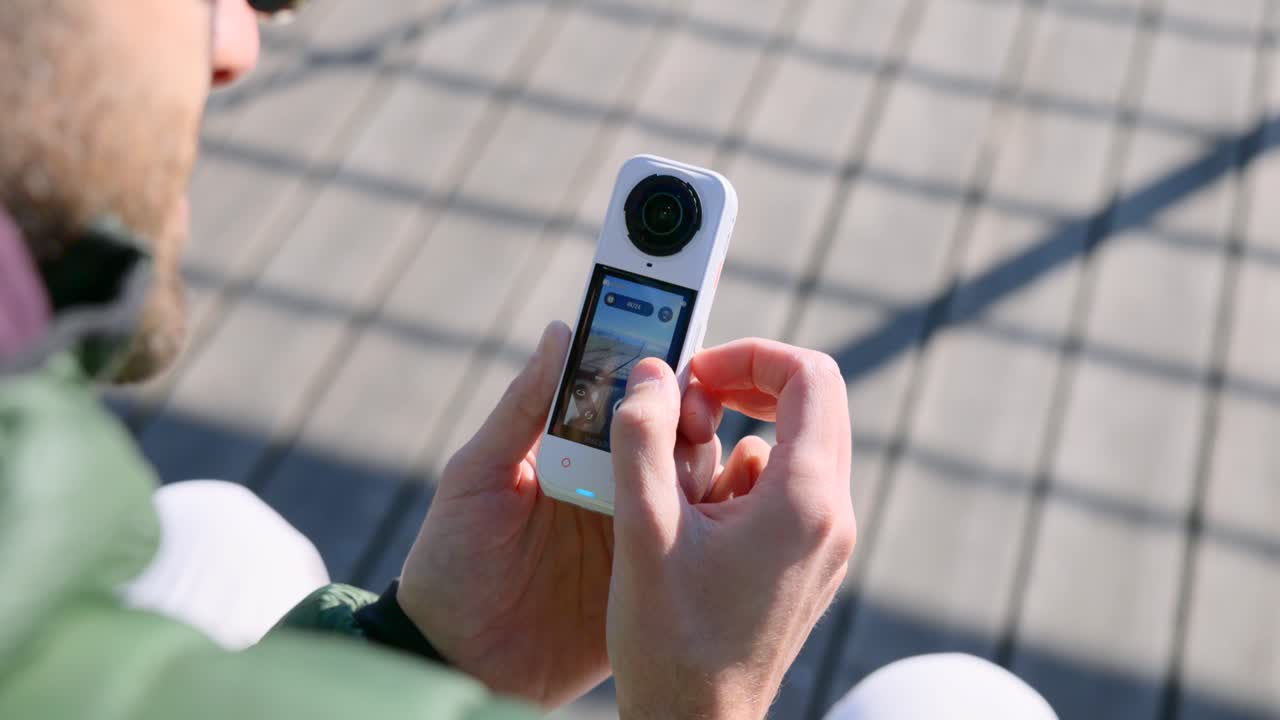 Vista de um homem usando a tela sensível ao toque de uma nova câmera Insta360 X5 360.