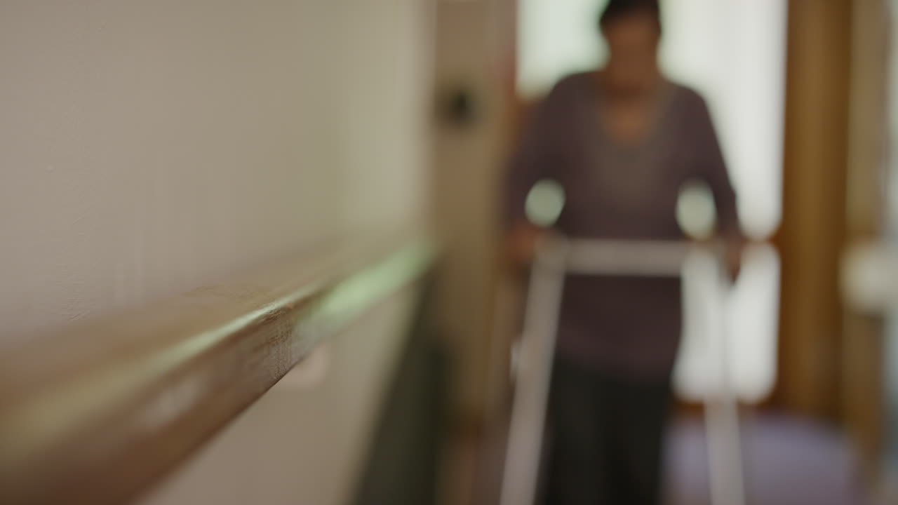 퇴직자 집 로비 에서 천천히  ⁇ 고 있는 보행자 도움 을 사용하는 노인 여자