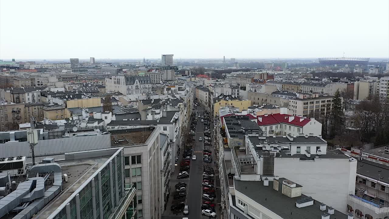 Aerial view over a narrow street in cloudy Warsaw, in Poland - reverse, drone shot