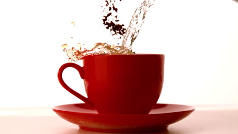 Kaffeegranulat-Und-Wasser-Fallen-In-Eine-Rote-Tasse