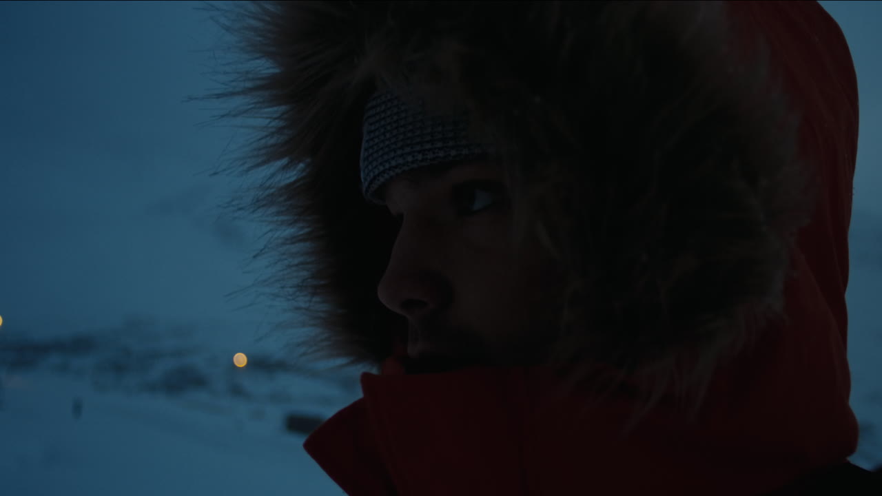 Closeup moody silhouette of man in fur lined jacket in the arctic
