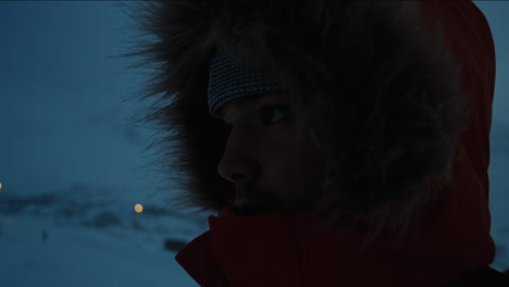 closeup moody silhouette of man in fur lined jacket in the arctic