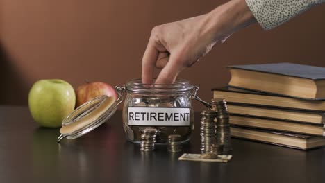 male taking money from glass with savings