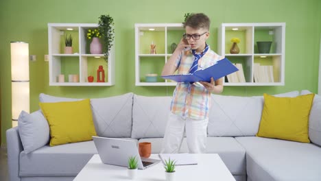el niño que finge ser un hombre de negocios en casa está jugando y divirtiéndose.