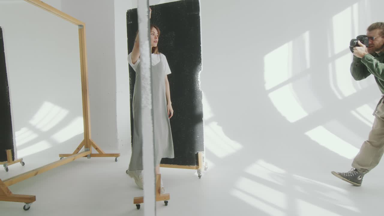 Bella modella che cammina e posa in studio durante un servizio fotografico.