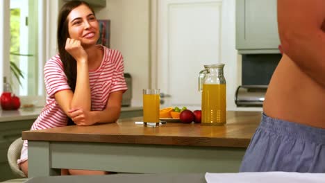 hombre guapo planchando mientras la mujer lo mira