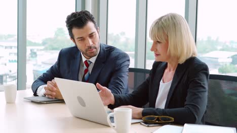 two business people talk project strategy at office