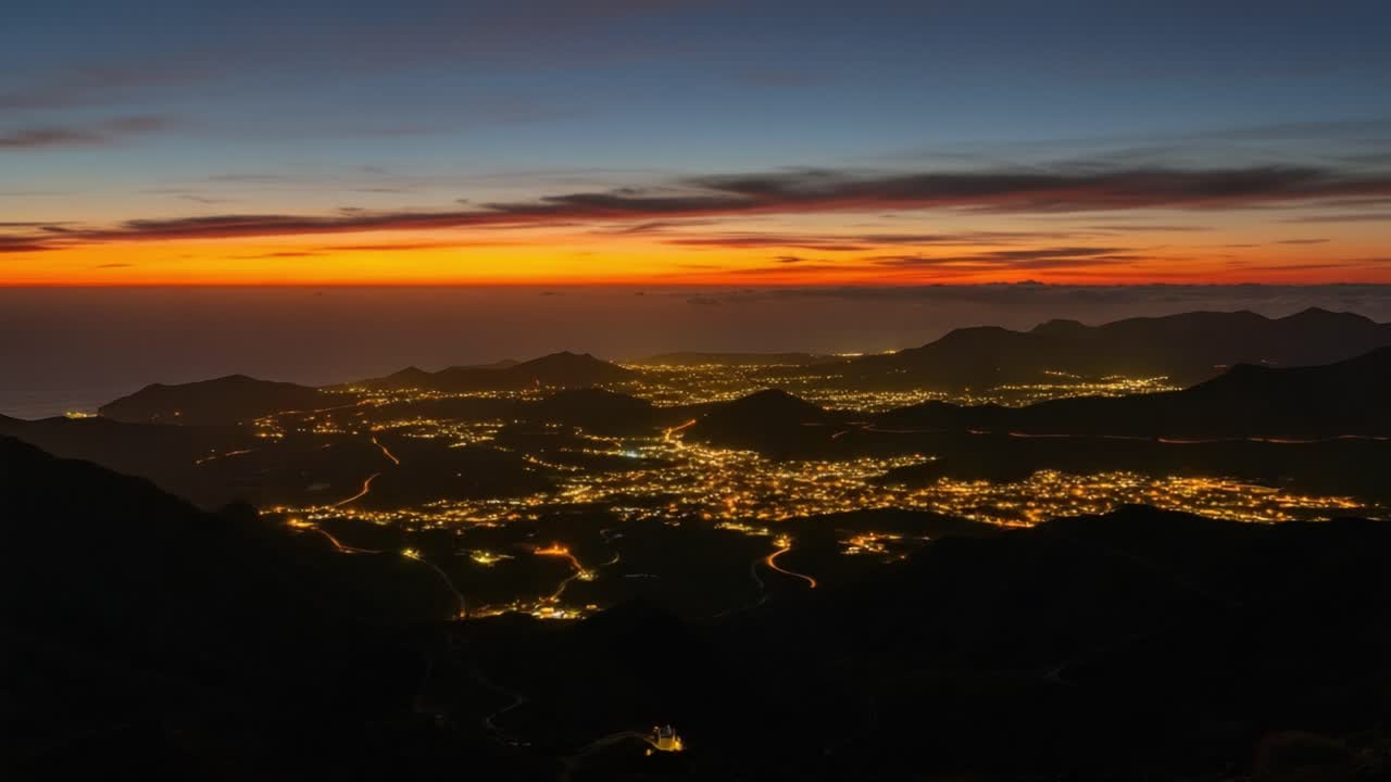 Illuminated Cityscape at Twilight Among Mountains