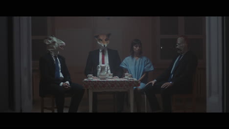a girl sits at a table with strange figures in animal masks