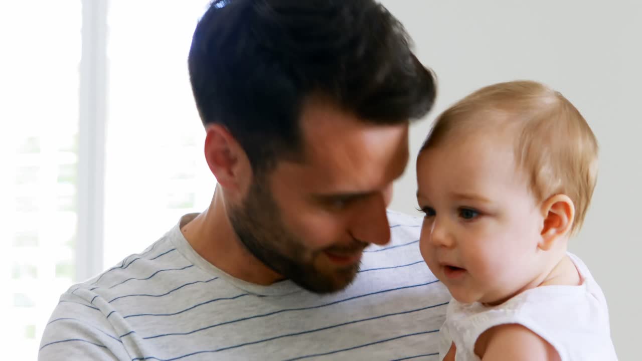 Padre che gioca con la sua bambina in camera da letto