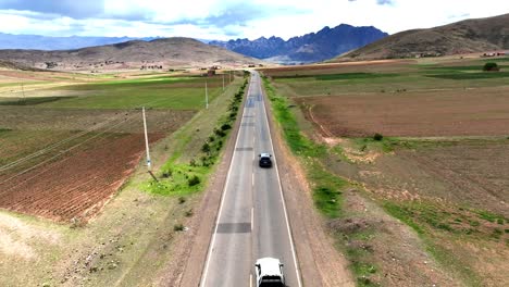 experimente la emoción de atravesar los sinuosos caminos de los andes de alta altitud bolivianos mientras un coche es seguido, con majestuosas montañas como telón de fondo y vibrantes granjas a lo largo de la carretera