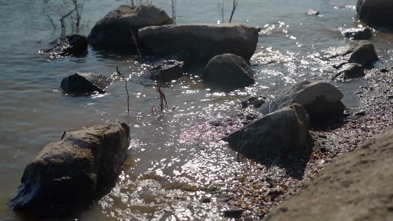 Close-up of rocks partially submerged in water along a river