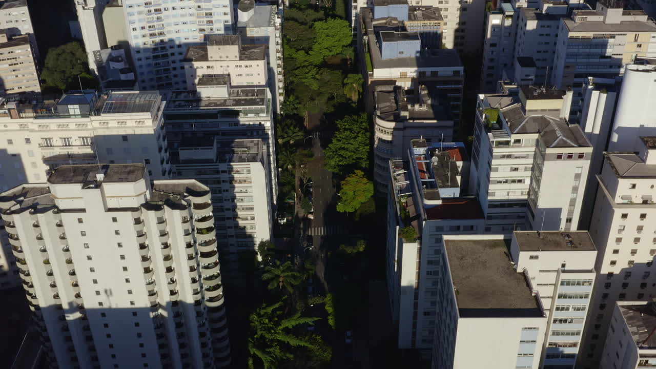 Filmagem aérea de drone revelando a paisagem urbana de uma grande metrópole passando por grandes edifícios na cidade de São Paulo, Brasil, com Dolly In e Tilt Up.