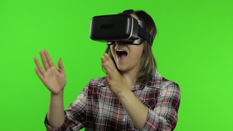 young woman using vr headset helmet to play game. watching virtual reality 3d 360 video. chroma key