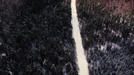 Luftaufnahme-Einer-Drohne,-Die-Im-Winter-über-Eine-Forststraße-Fliegt