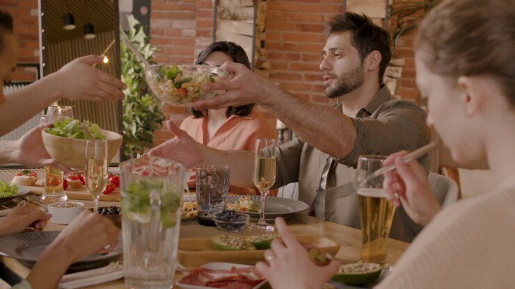 Un ragazzo che si serve l'insalata a una cena