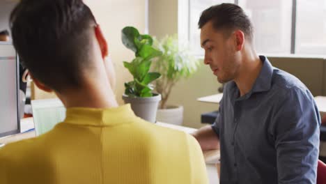 Gente-De-Negocios-Caucásica-Feliz-Sentada-A-La-Mesa-Y-Discutiendo-El-Trabajo-En-La-Oficina