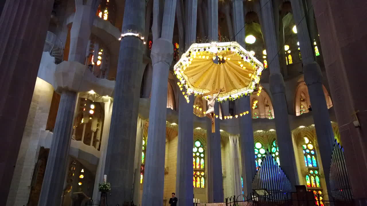 Basílica de la Sagrada Família, Barcelona, Spain, designed by Catalan architect Antoni Gaudí, UNESCO world heritage site, 4k, DJI Osmo stabilized walking past columns to crucifix, altar, stained glass