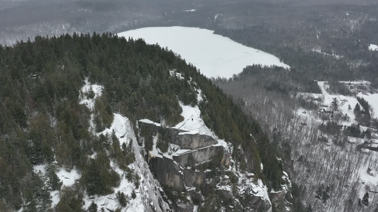 paisaje invernal sobre la montaña en quebec, canadá con excursionista de pie en la cima