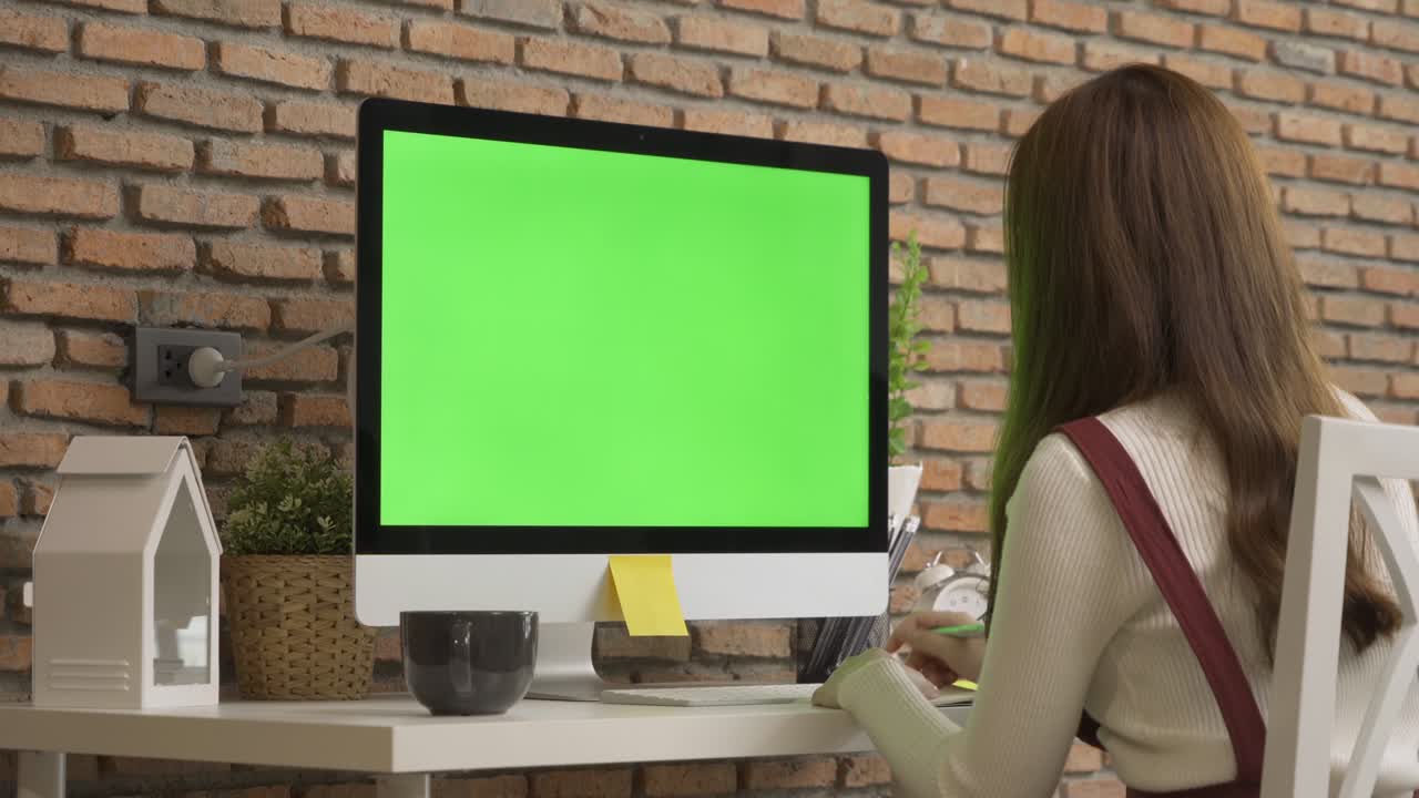 mujer de negocios asiática, joven trabajando desde casa en la mesa con computadora y espacio en pantalla verde en blanco en la webcam videoconferencia de llamada en cuarentena en concepto de virus de corona.